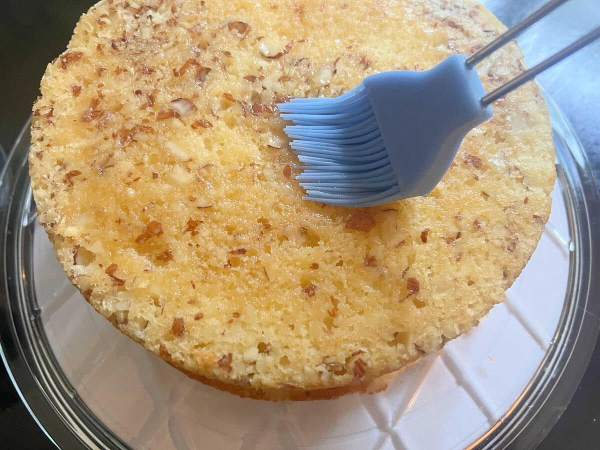 مرطوب کردن لایه کیک آمارِتو با شربت ساده، طرز تهیه کیک آمارِتو.