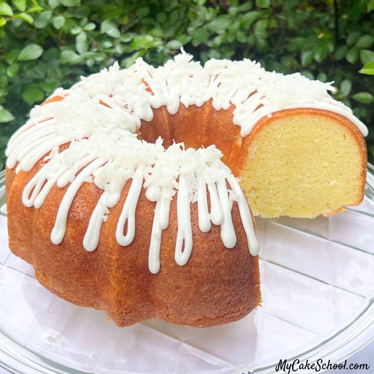 طرز تهیه کیک نارگیلی حلقه ای، برش خورده، روی ظرف کیک.