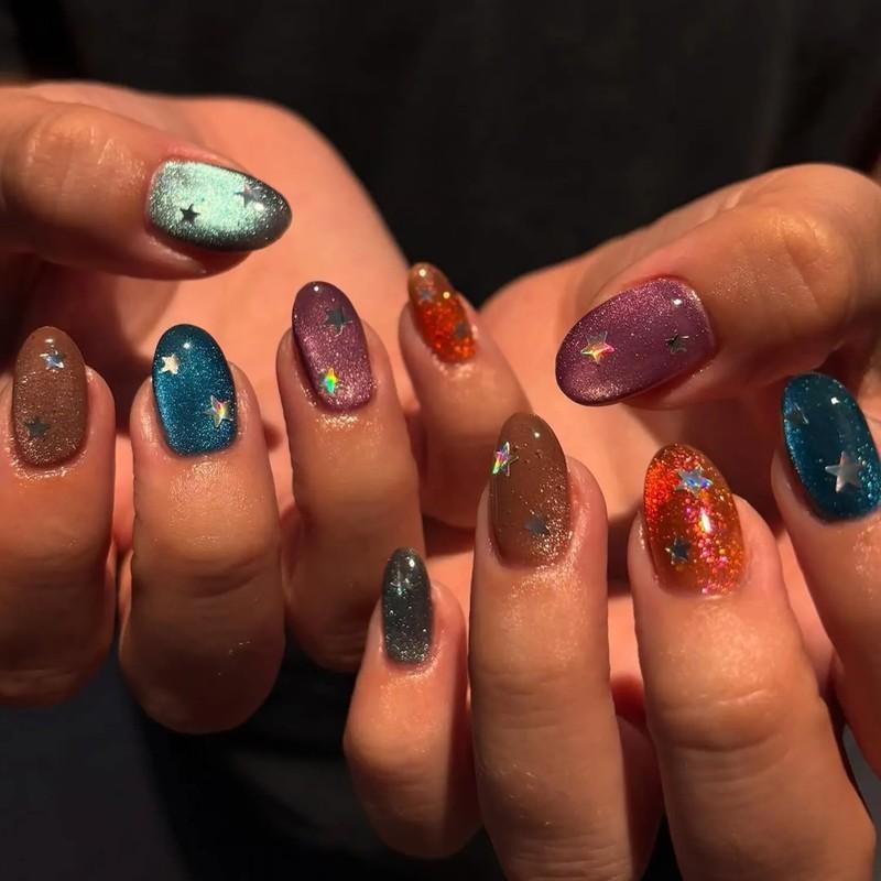 Hands with nails painted in various colors embellished with star designs - مدل ناخن مخملی