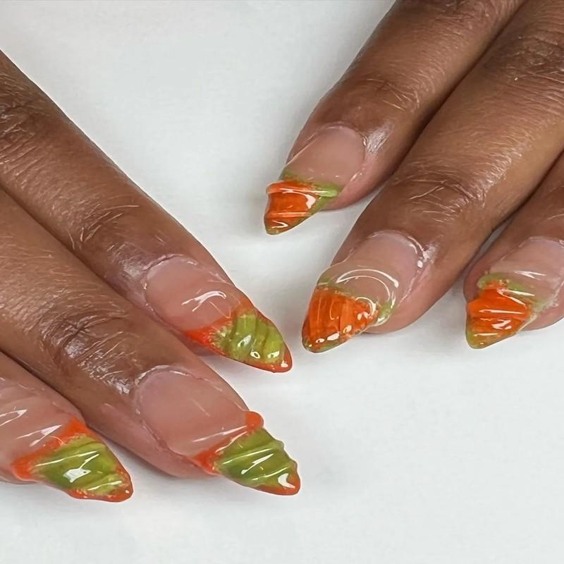 ایده ناخن زیتونی: Closeup of hands showcasing nails with ornate orange and green designs