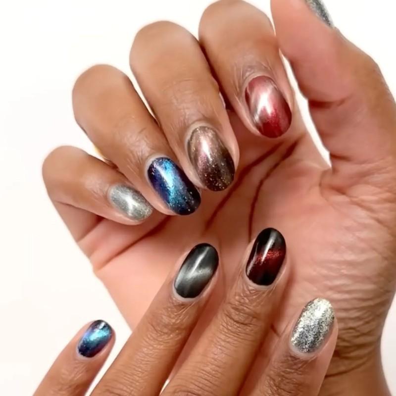 Hand with nails painted in various shiny metallic colors with cat eye finish, مدل ناخن کوتاه پاییزی چشم گربه ای