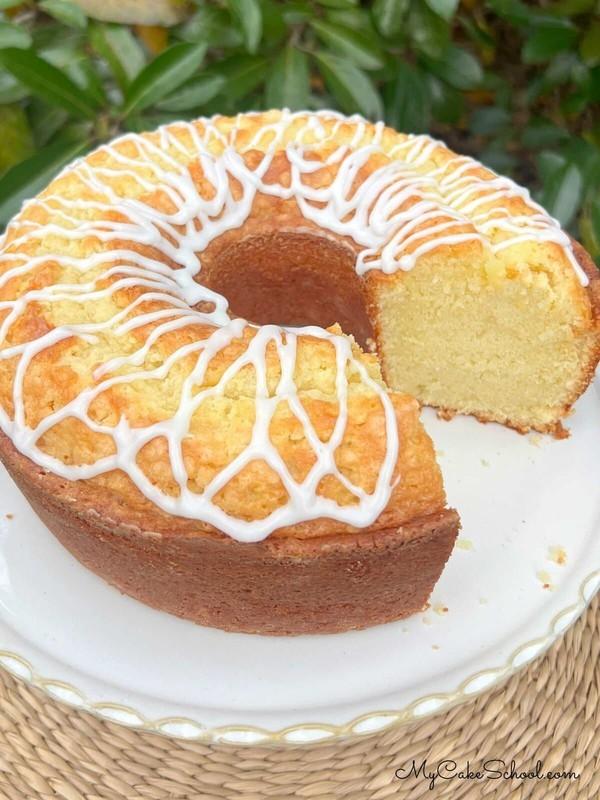 طرز تهیه کیک نارگیلی خامه ای - پوند کیک نارگیلی با خامه، برش خورده، روی پایه کیک.