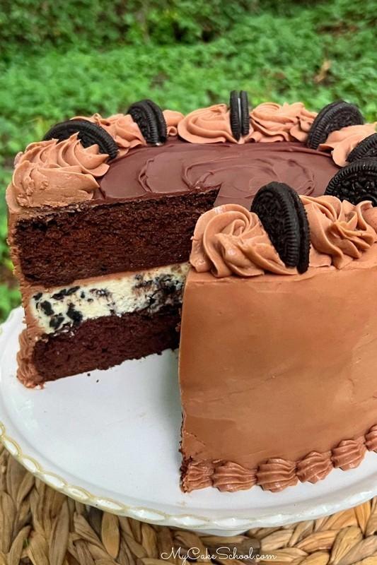 طرز تهیه کیک چیزکیک اوریو، برش خورده، روی پایه مخصوص.