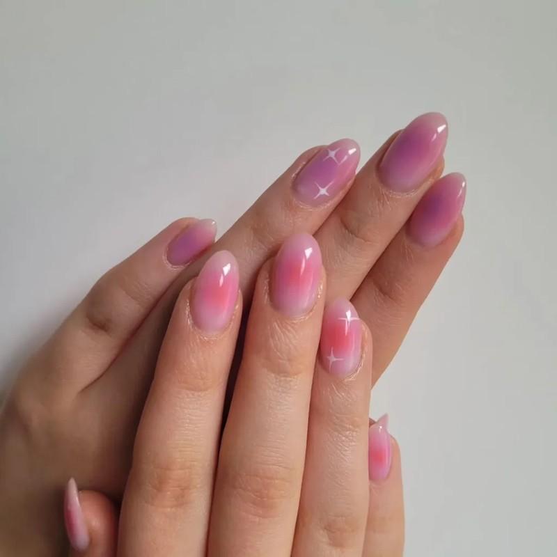 طراحی ناخن اورا بادامی صورتی روشن با طرح ستاره آسمانی سفید و رنگ های بنفش ملایم