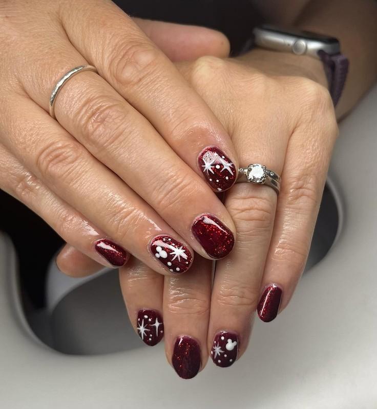 طراحی ناخن کریسمس با اکلیل زرشکی و دانه های برف